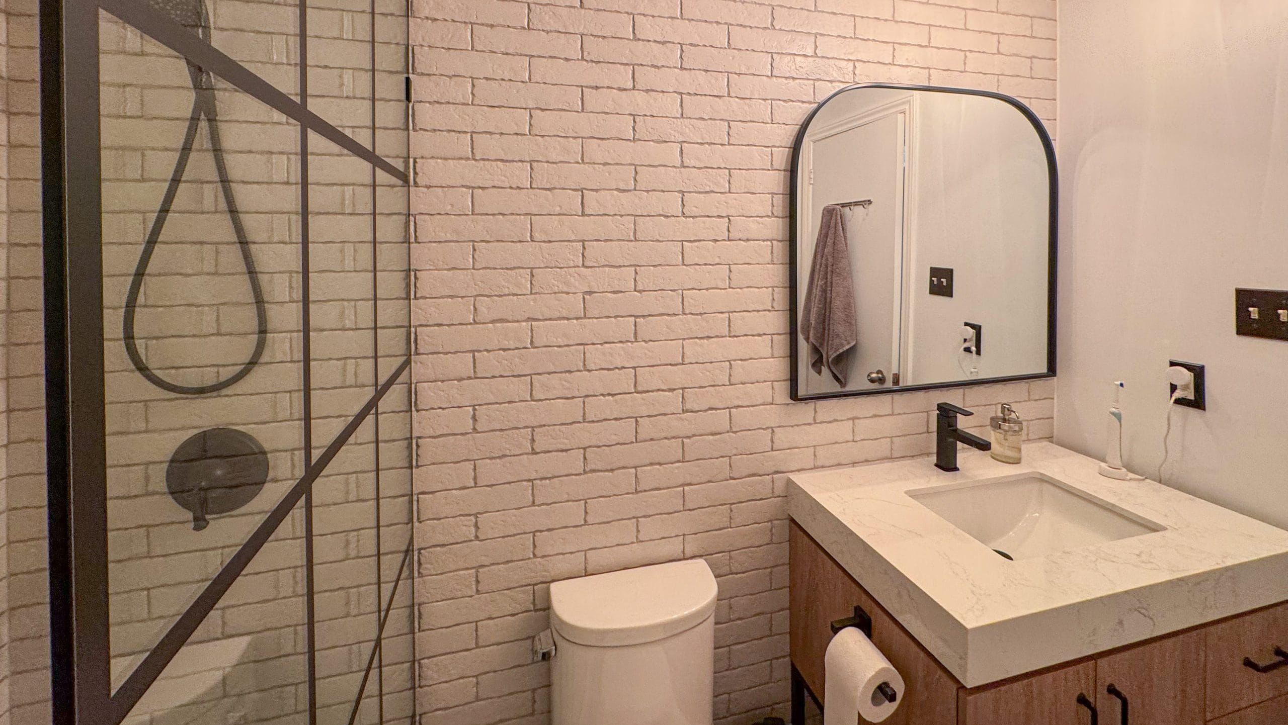 Black-framed shower with white textured wall tile in the Riverside bathroom project.