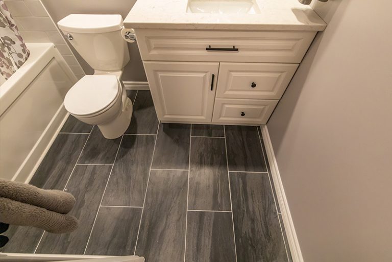 Basmenet bathroom with vanity toilet tub and shower and tiled floor in Ottawa