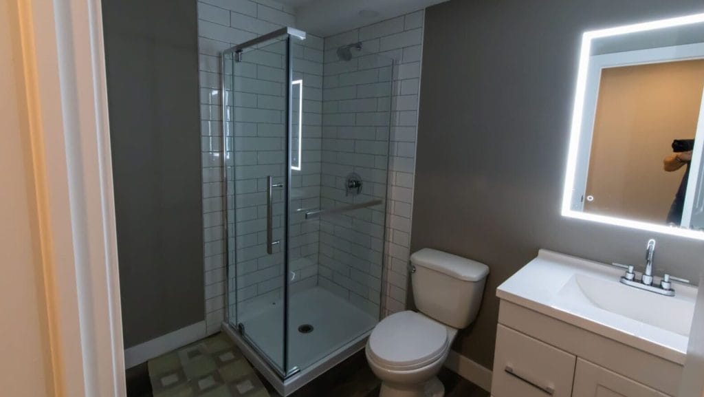 LED mirror in basement bathroom with tiled shower in Almonte