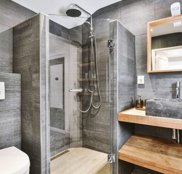 A clean bathroom featuring a shower, sink, and toilet, designed for functionality and comfort.