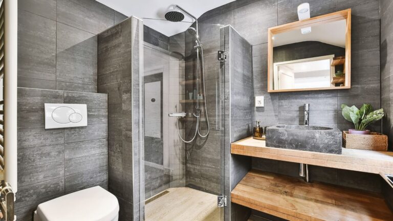 A clean bathroom featuring a shower, sink, and toilet, designed for functionality and comfort.