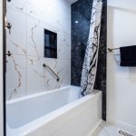 Bathroom renovation in Ottawa tub and large tile walls black and white tiles