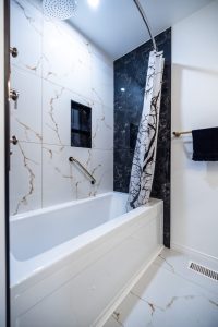 Bathroom renovation in Ottawa tub and large tile walls black and white tiles